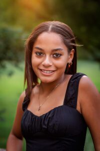 family photographer in rochester ny captures senior portraits for high school senior in a park at sunset