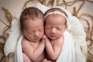 newborn photographer in rochester ny captures newborn twins holding hands