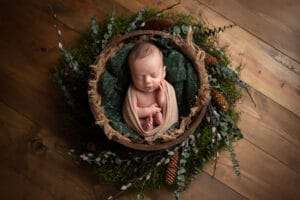 newborn photographer in rochester ny captures newborn baby boy sleeping in a rustic pine wreath