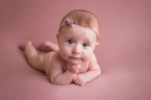 baby photographer in rochester ny captures baby girl with her chin on her hands