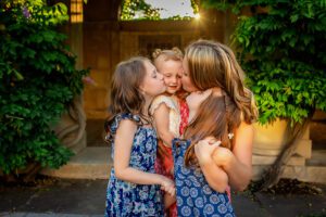 family photographer in rochester ny captures family kissing baby in the George Eastman Museum Gardens