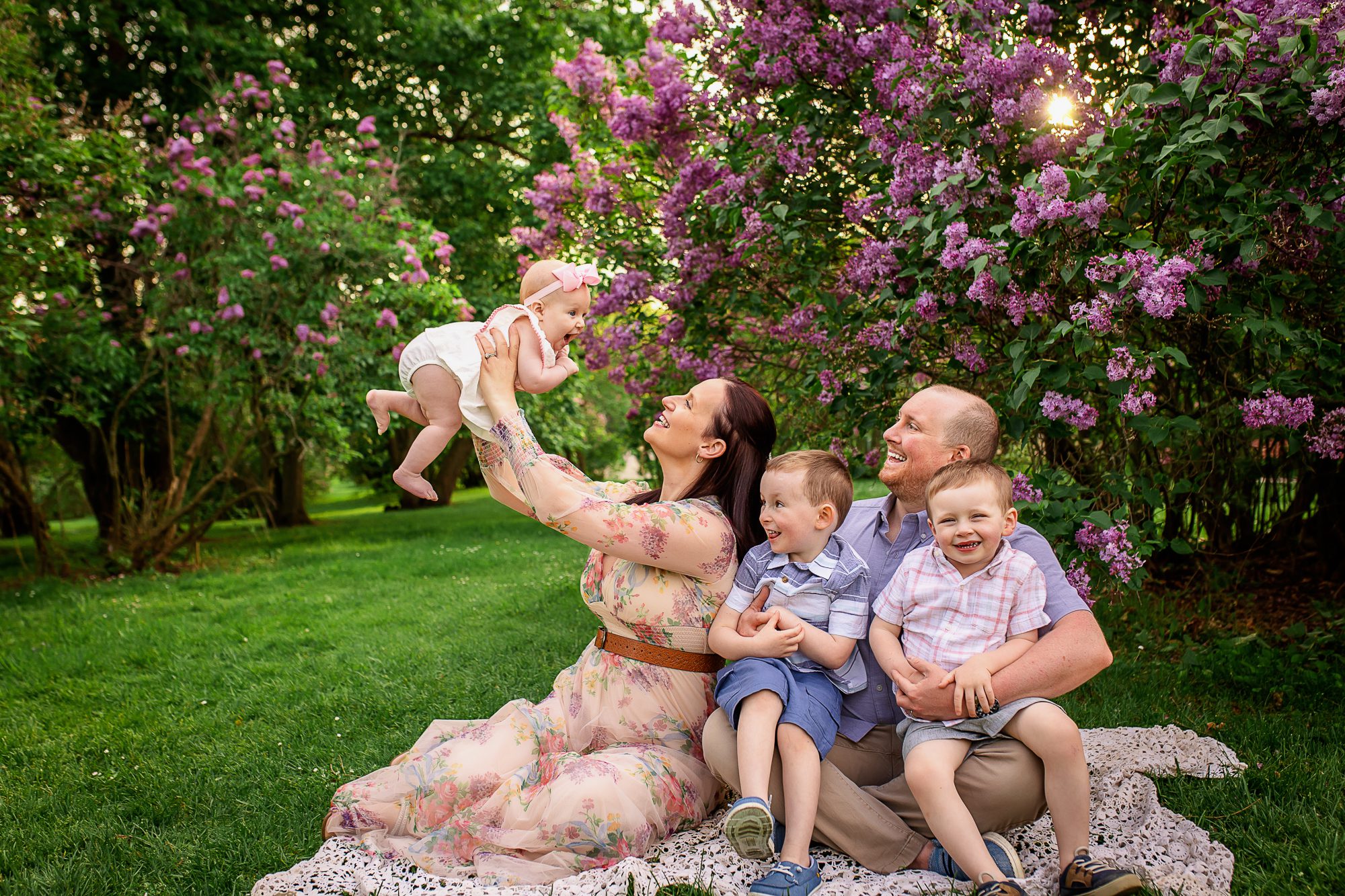 family photographer in rochester ny captures family playing together in the lilacs