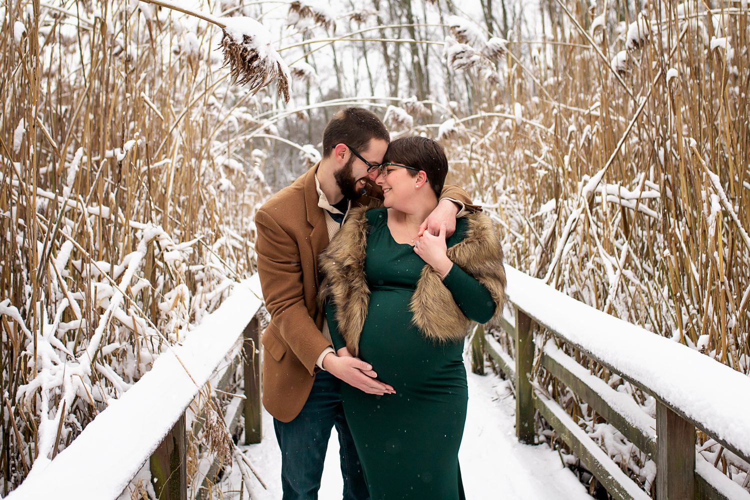 maternity photographer in rochester ny captures expectant parents in the snow