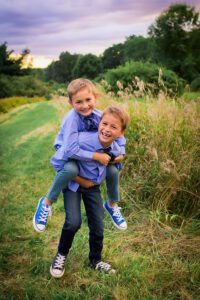 family photographer in rochester ny captures brothers giving a piggy back ride