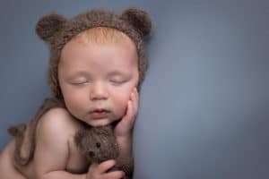 newborn photographer in rochester ny captures baby boy sleeping with teddy bear