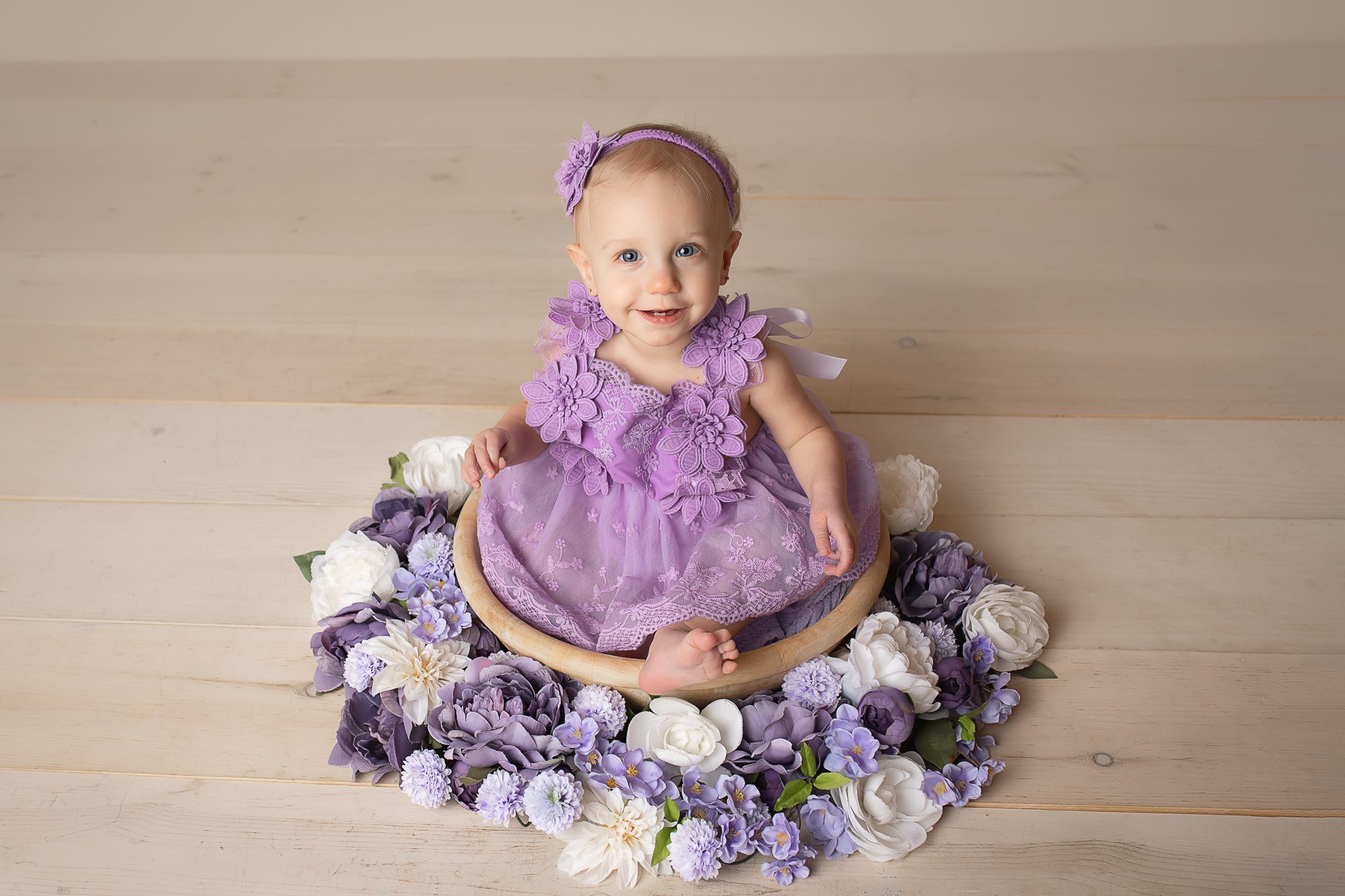 baby photographer in rochester ny captures baby girl smiling in a floral wreath