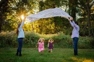 family photographer in rochester ny captures family playing in the sunset