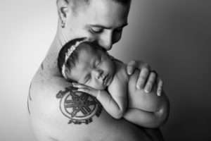 newborn photographer in rochester ny captures newborn baby girl sleeping in dad's arms
