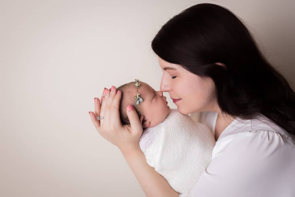 newborn photographer in rochester ny captures newborn baby girl sleeping in moms arms
