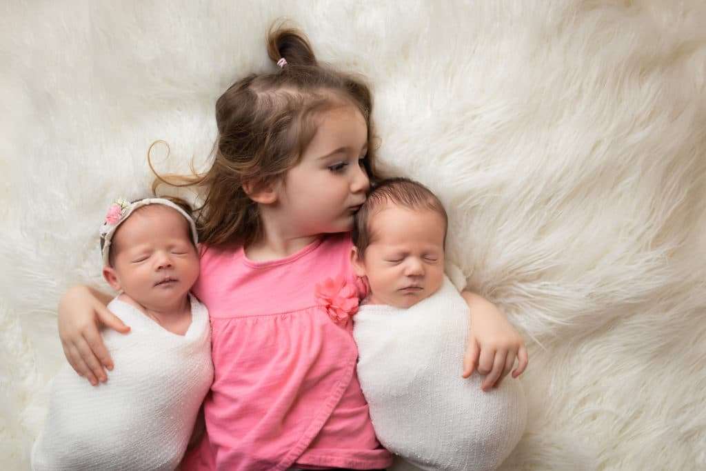 newborn photographer in rochester ny captures newborn twins sleeping with their big sister