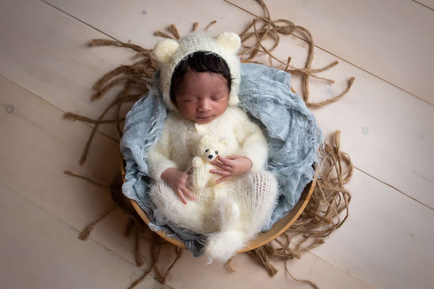 newborn photographer in rochester ny captures newborn baby boy sleeping in teddy bear outfit