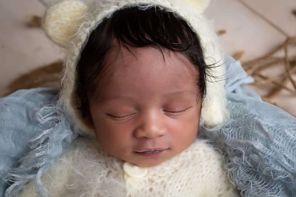 newborn photographer in rochester ny captures newborn baby boy sleeping in teddy bear outfit