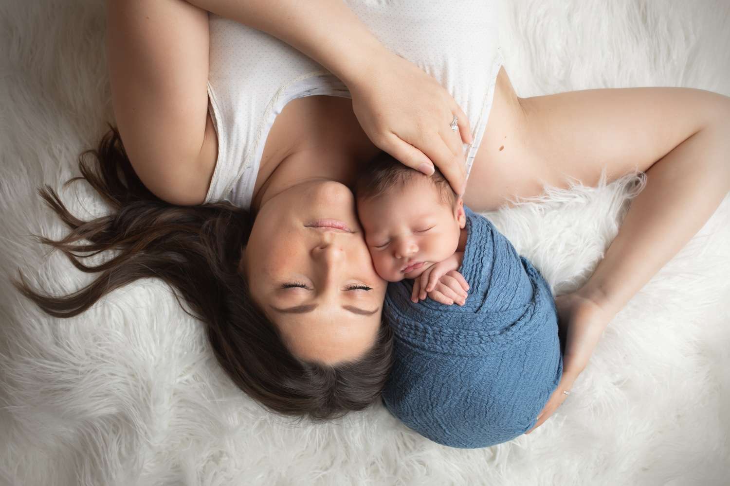 newborn photographer in rochester ny captures newborn baby boy sleeping in his mom's arms