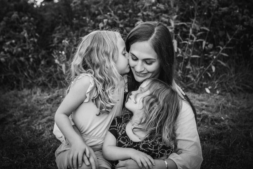 family photographer in rochester ny captures family playing together in a field at sunset