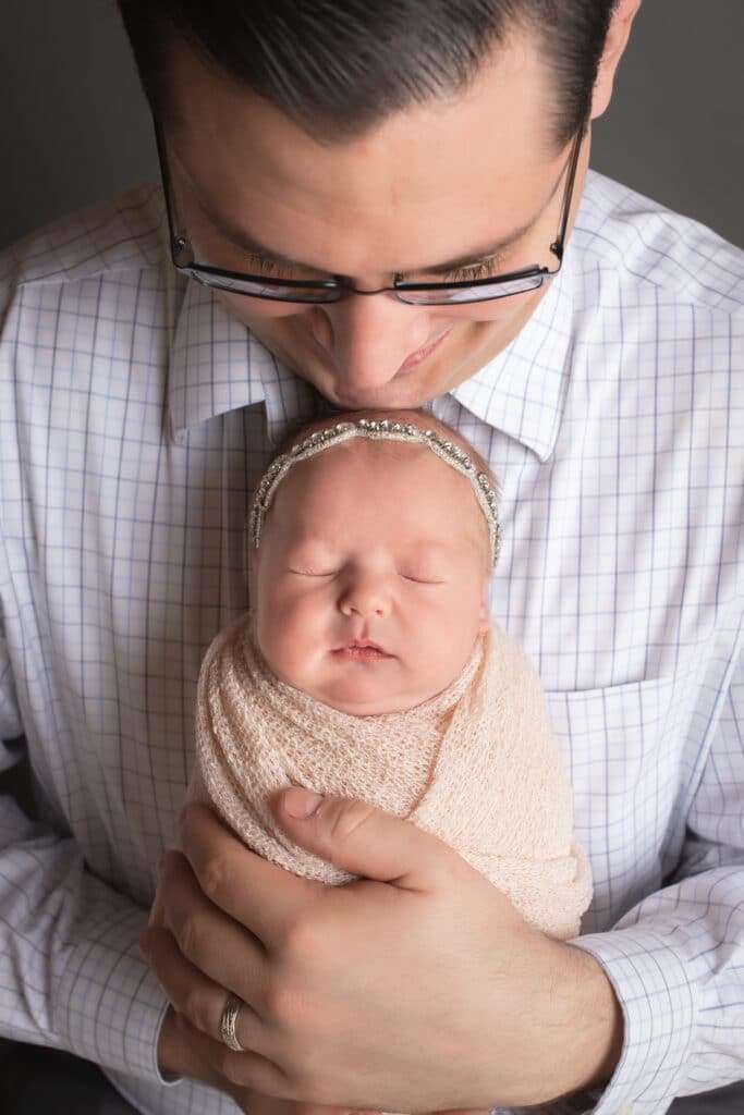 newborn photographer in rochester ny captures sleeping newborn baby in her dad's arms