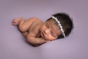 newborn photographer in rochester ny captures baby girl sleeping in side lay pose