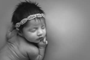 newborn photographer in rochester ny captures baby girl sleeping in black and white
