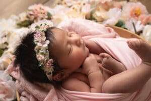 newborn photographer in rochester ny captures baby girl sleeping in the flowers