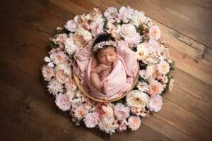 newborn photographer in rochester ny captures baby girl sleeping in a floral wreath