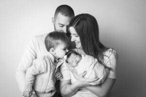 newborn photographer in rochester ny captures family holding their newborn baby girl