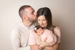 newborn photographer in rochester ny captures family holding their newborn baby girl