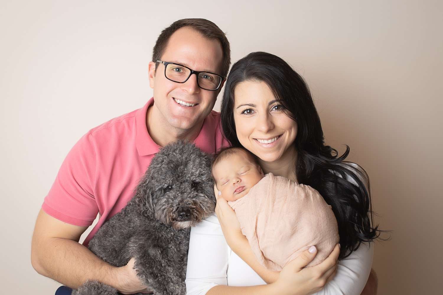 newborn photographer in rochester ny captures newborn baby girl sleeping in her parents' arms