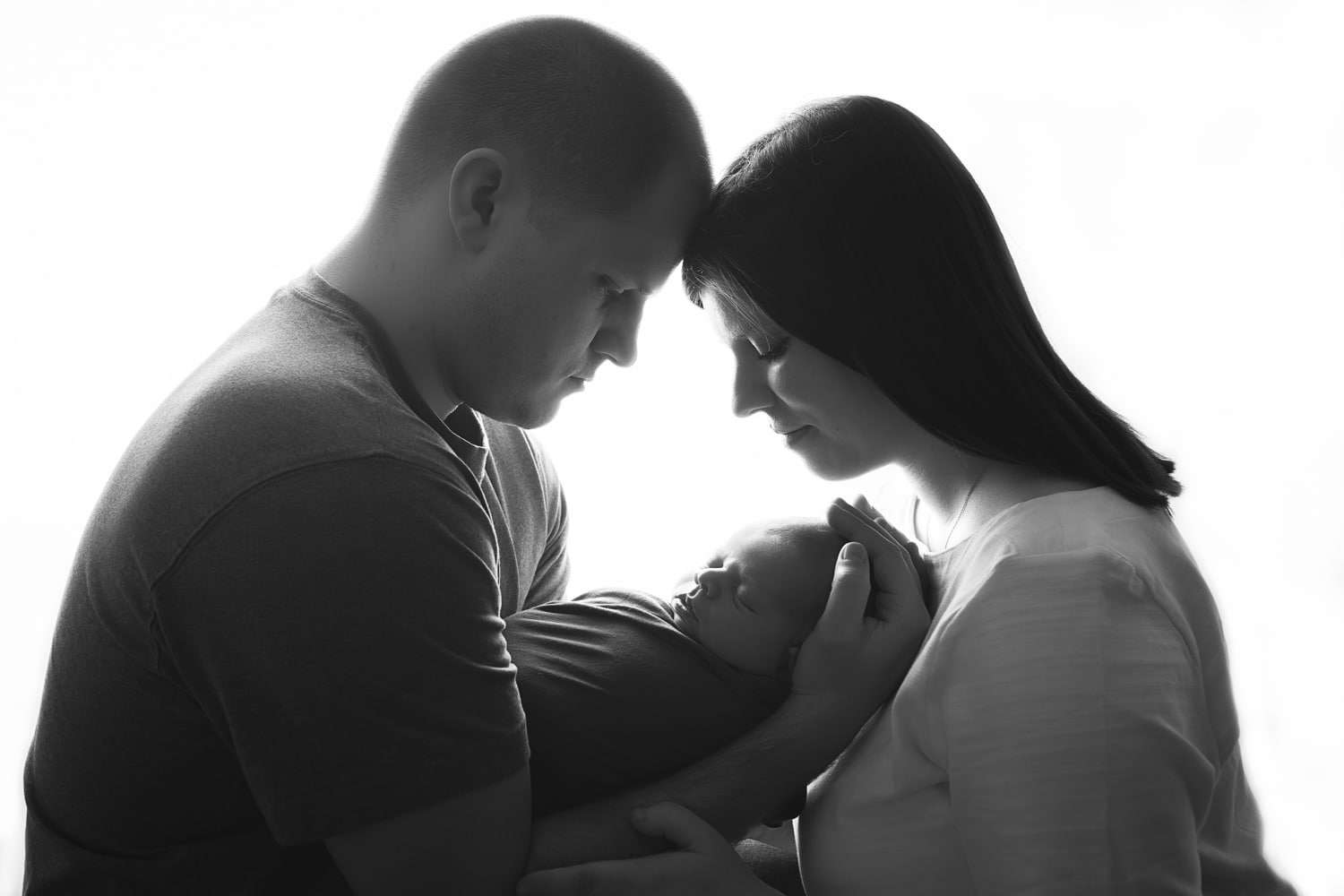 newborn photographer in rochester ny captures newborn baby boy in his parents arms