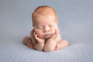 newborn photographer in rochester ny captures newborn baby boy sleeping in froggy pose
