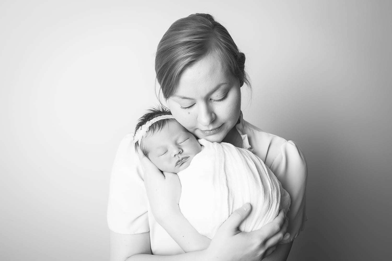 newborn photographer in rochester ny captures newborn baby girl sleeping in mom's arms