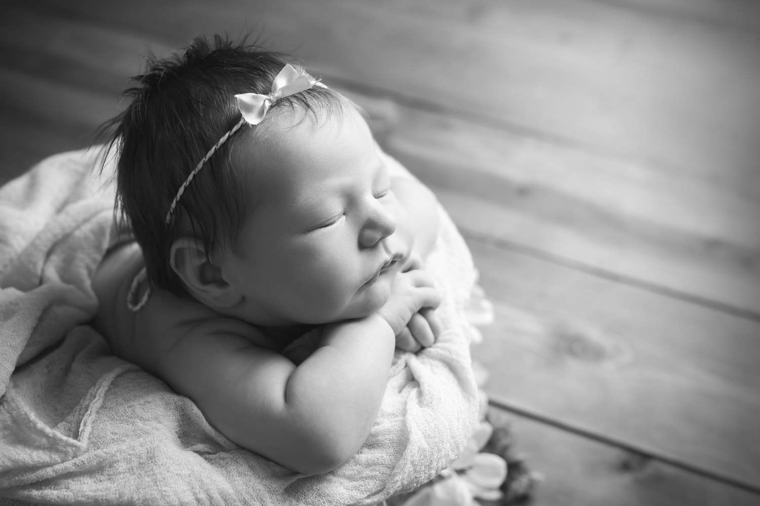 newborn photographer in rochester ny captures newborn baby girl sleeping chin on hands in a bucket