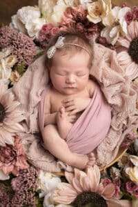 newborn photographer in rochester ny captures newborn baby girl sleeping in a floral wreath