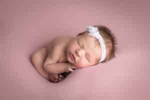 newborn photographer in rochester ny captures newborn baby girl sleeping in womb pose