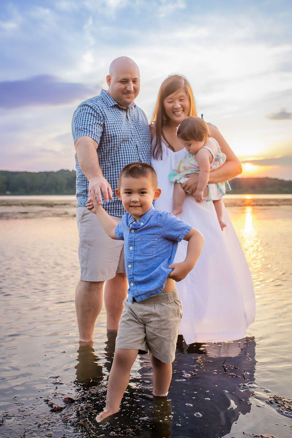 family photographer in rochester ny captures family portraits as the sun sets over the large pond at mendon ponds park