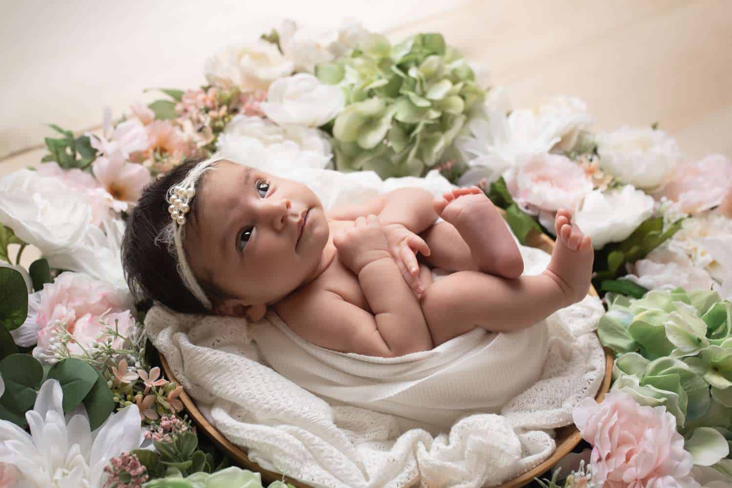 newborn photographer in rochester ny captures newborn baby girl in a spring floral wreath