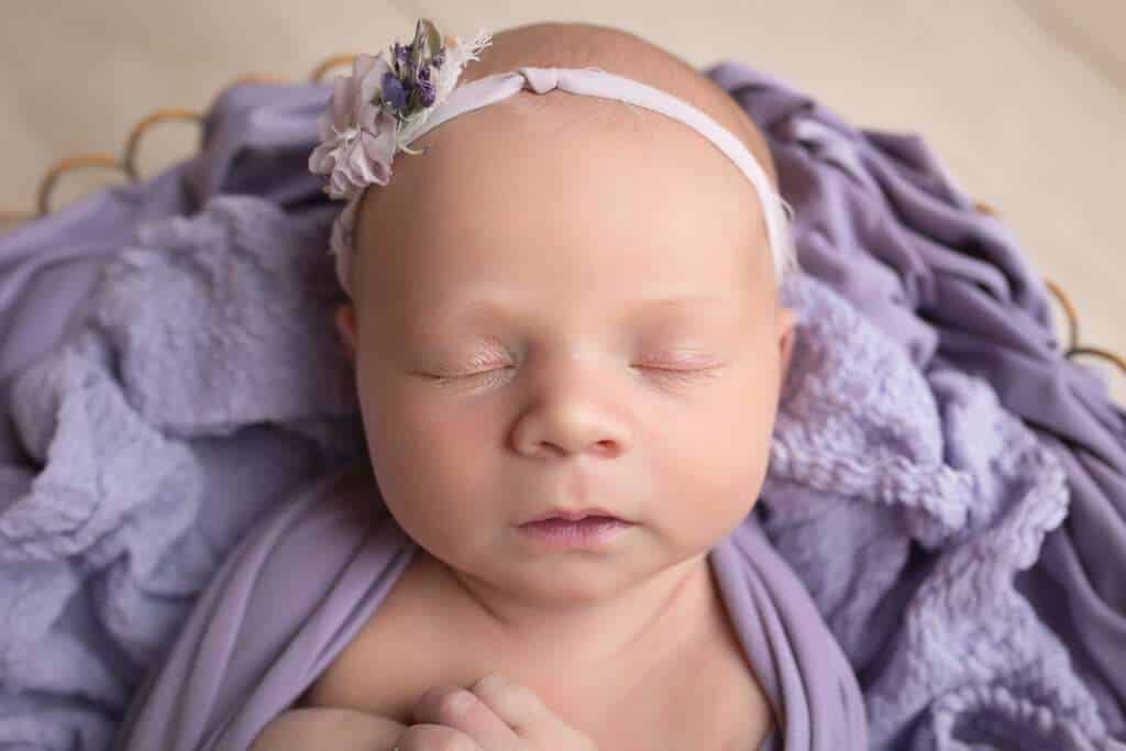 newborn photographer in rochester ny captures newborn baby girl in purple