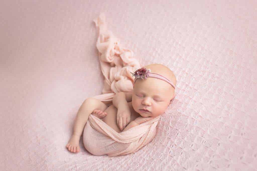 newborn photographer in rochester ny captures newborn baby girl in wrapped huck fin pose