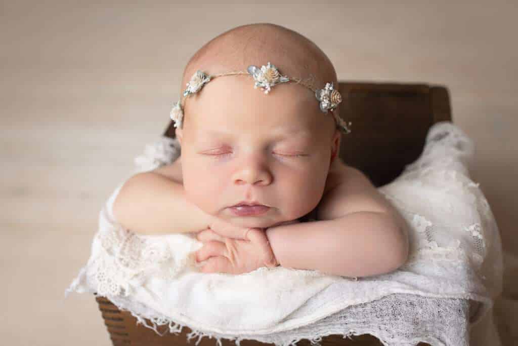 newborn photographer in rochester ny captures newborn baby girl with chin on hands