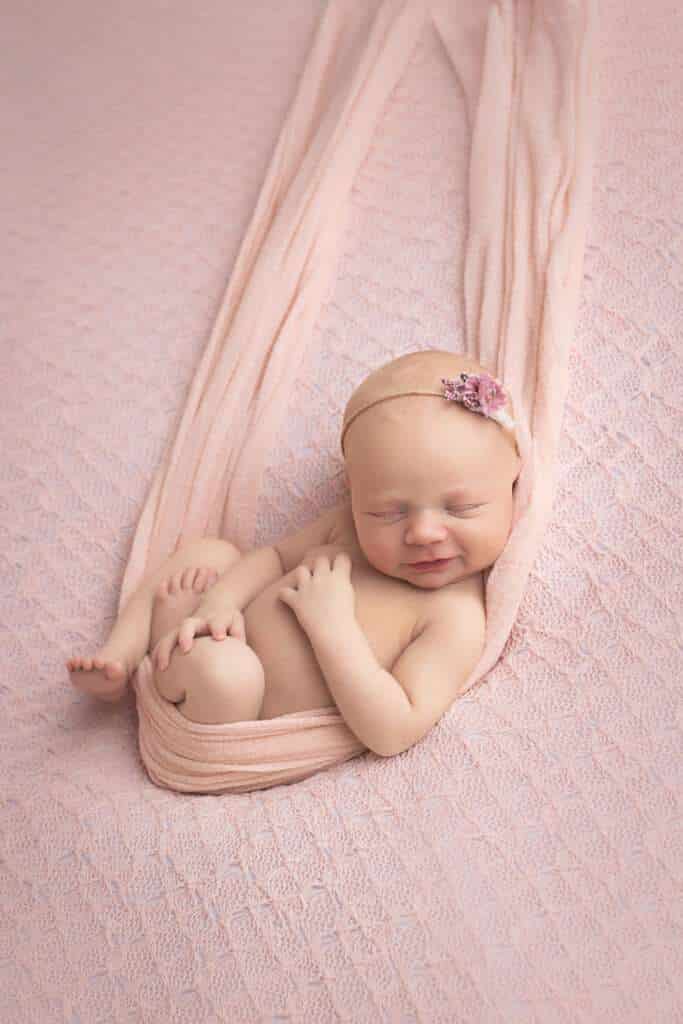 newborn photographer in rochester ny captures newborn baby girl sleeping in a hammock
