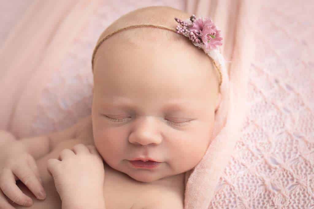 newborn photographer in rochester ny captures newborn baby girl smiling