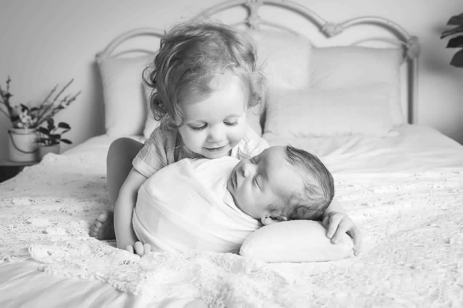 newborn photographer in rochester ny captures newborn baby boy asleep with his big sister