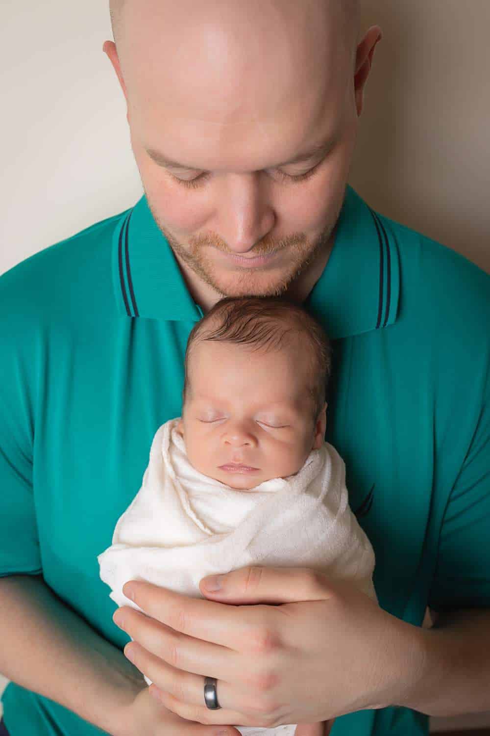 newborn photographer in rochester ny captures newborn baby boy asleep in his dad's arms