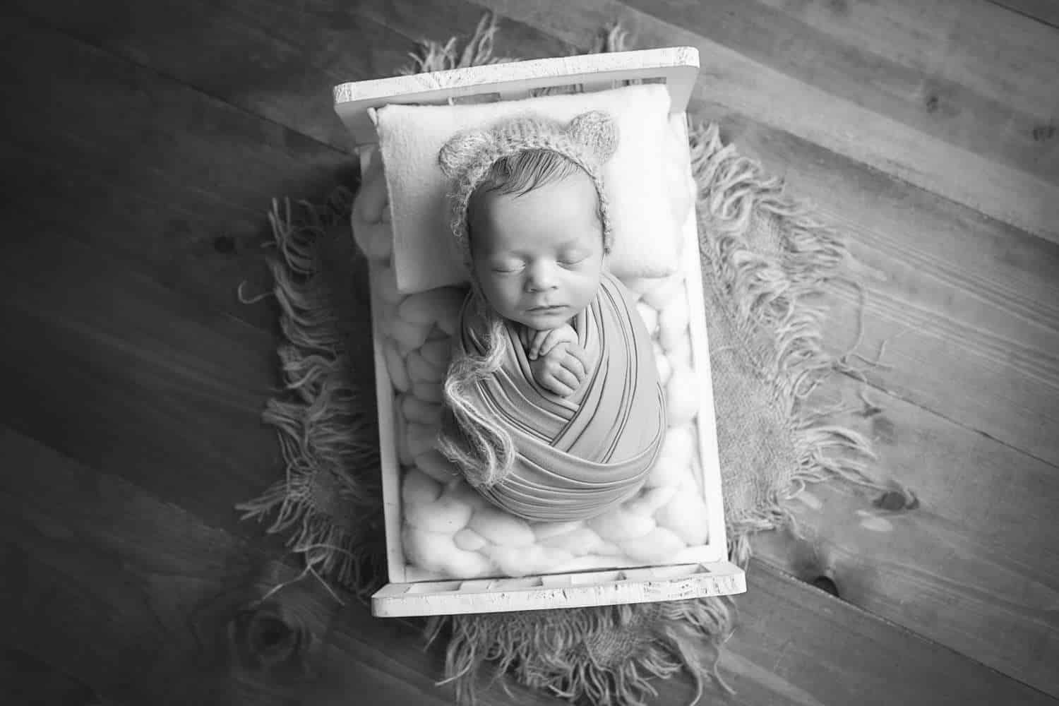 newborn photographer in rochester ny captures newborn baby boy asleep on a tiny bed