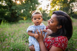 family photographer in rochester ny captures mom and daughter snuggling together in the flowers