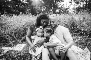 family photographer in rochester ny captures family snuggling together in the flowers