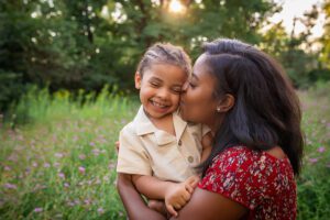 family photographer in rochester ny captures mom and son snuggling together in the flowers