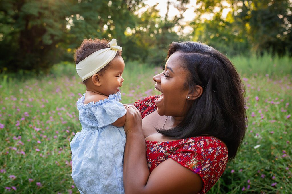 family photographer in rochester ny captures mom and daughter snuggling together in the flowers