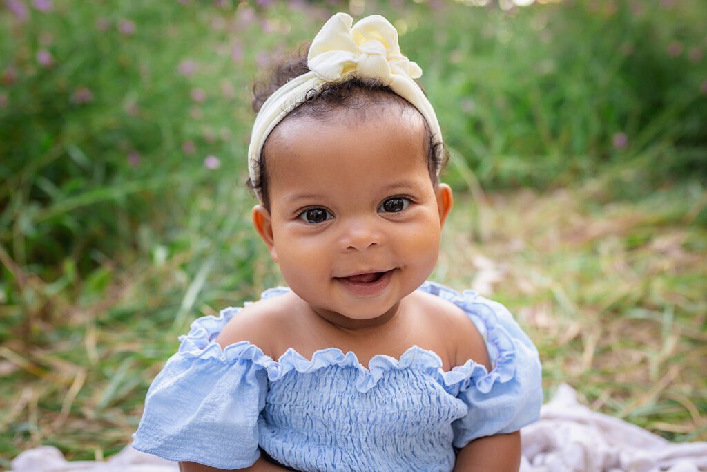 family photographer in rochester ny captures little girl smiling in the flowers