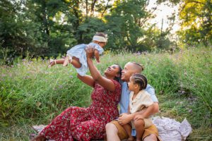 family photographer in rochester ny captures family playing together in the flowers