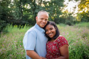 family photographer in rochester ny captures mom and dad smiling together in the flowers